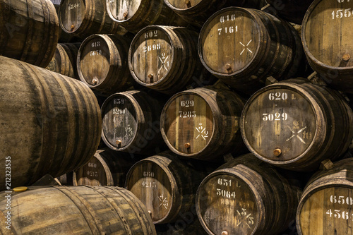 Tablou canvas Row of wooden porto wine barrels in wine cellar Porto, Portugal.