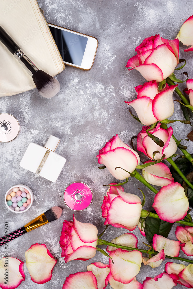Still life of fashion woman. Women's fashion with bouquet of roses, cosmetics, phone and glasses on stone background, copy space