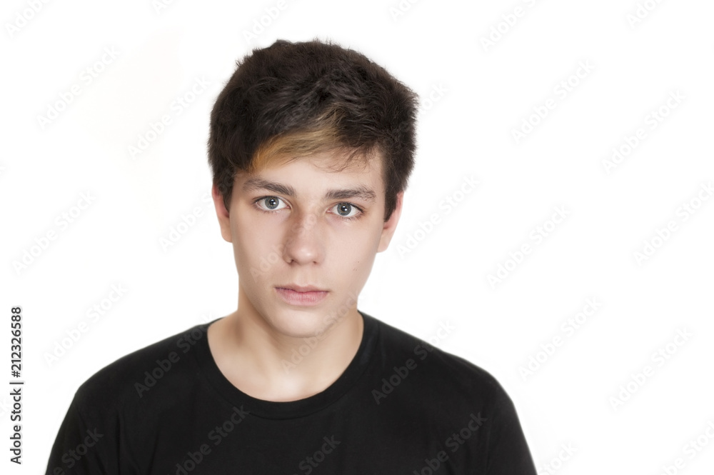 A teenager with a serious face and a black T-shirt on a white background A teenager with a serious face and a black T-shirt on a white background