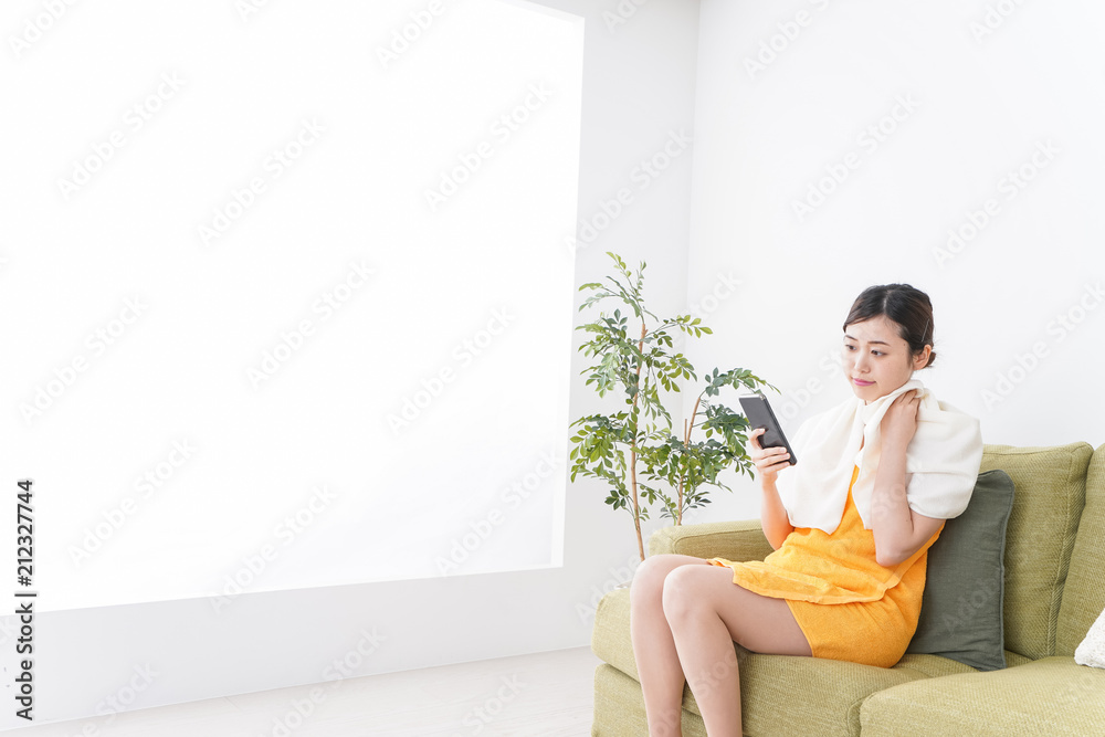 お風呂上がりにスマホをいじる女性 お風呂上がりにスマホをいじる女性