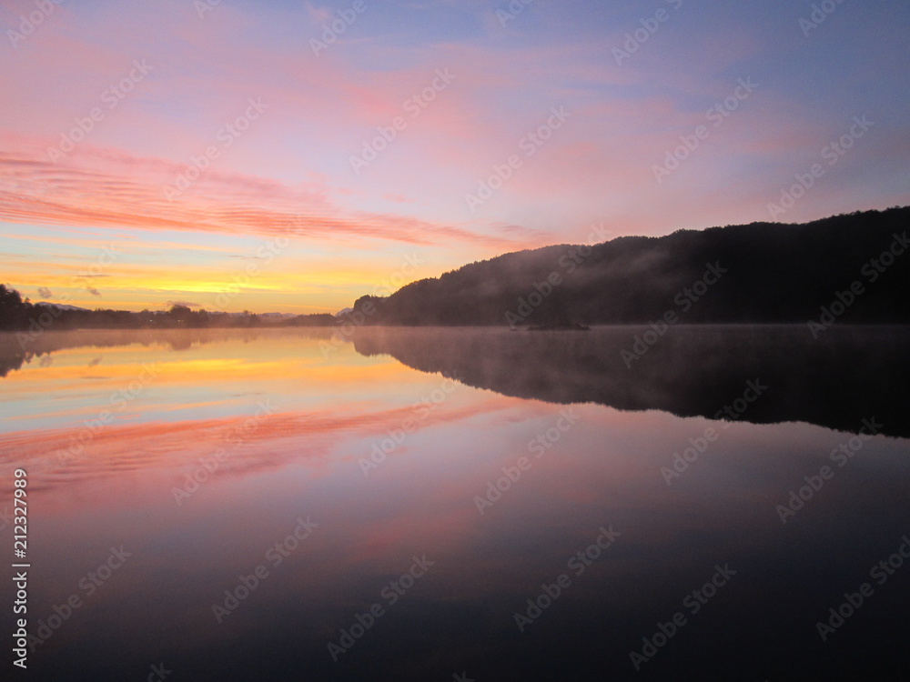 Sunrise over the lake...Reflection of sunset in crystal clear water of the lake...Wolflake...Os...Norway