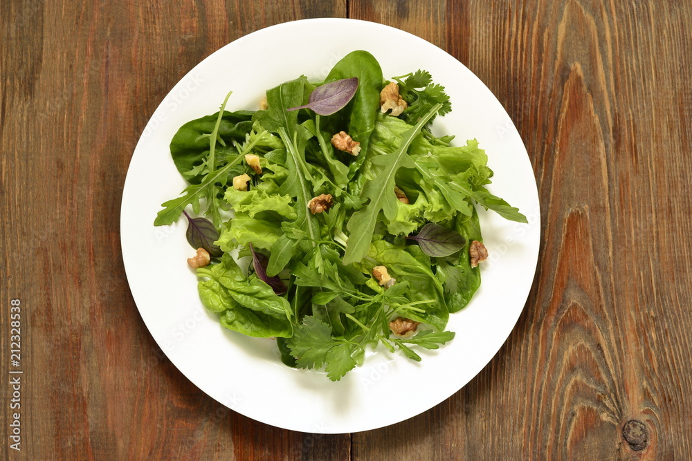 Fresh green salad with spinach, arugula, lettuce, herbs and nuts Fresh green salad with spinach, arugula, lettuce, herbs and nuts