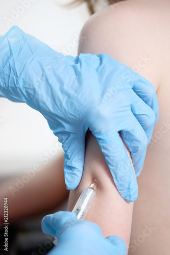 hands of nurse with syringe, vaccinating kid's arm