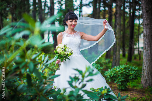 Wallpaper Mural Joyful bride in white wedding dress, waving veil, in summer green park Torontodigital.ca