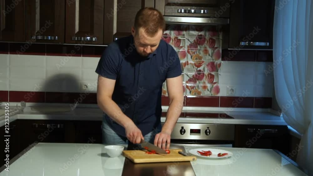 Slicing Red chili pepper. A man cuts pepper on a wooden Board Slicing Red chili pepper. A man cuts pepper on a wooden Board