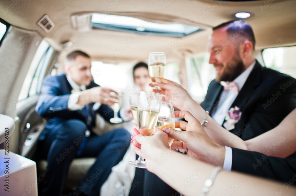 Groomsmen with bridesmaids and wedding couple drinking champagne in the