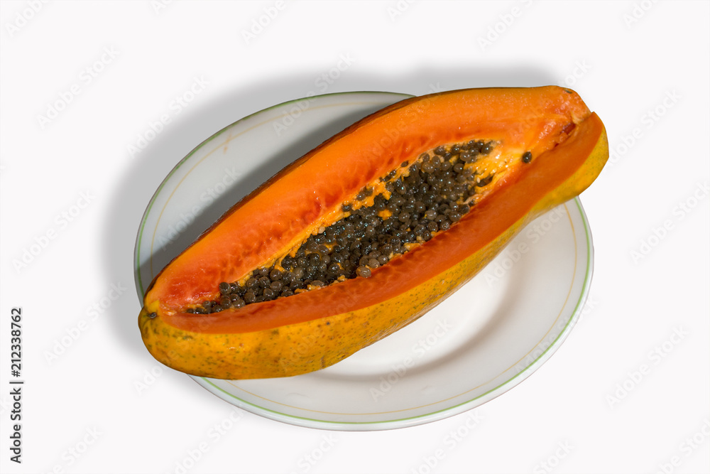 A slice of papaya on a white plate isolated in white background A slice of papaya on a white plate isolated in white background
