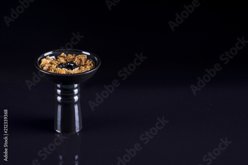 Hookah bowl with tobacco on black background