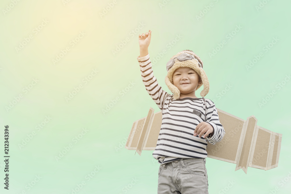 Happy child playing with toy wings against summer sky background. Happy child playing with toy wings against summer sky background.