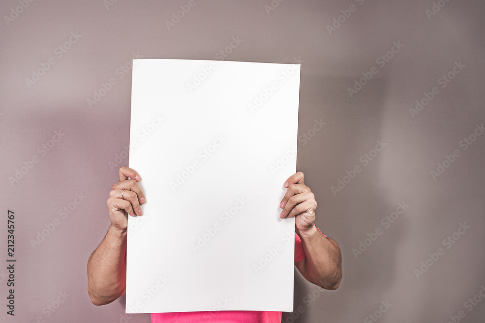 young man holding a blank poster with his hands young man holding a blank poster with his hands