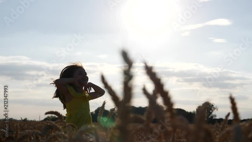 Happy running in wheat field nature cute kid girl in summer dress silhouette on sunset sun background