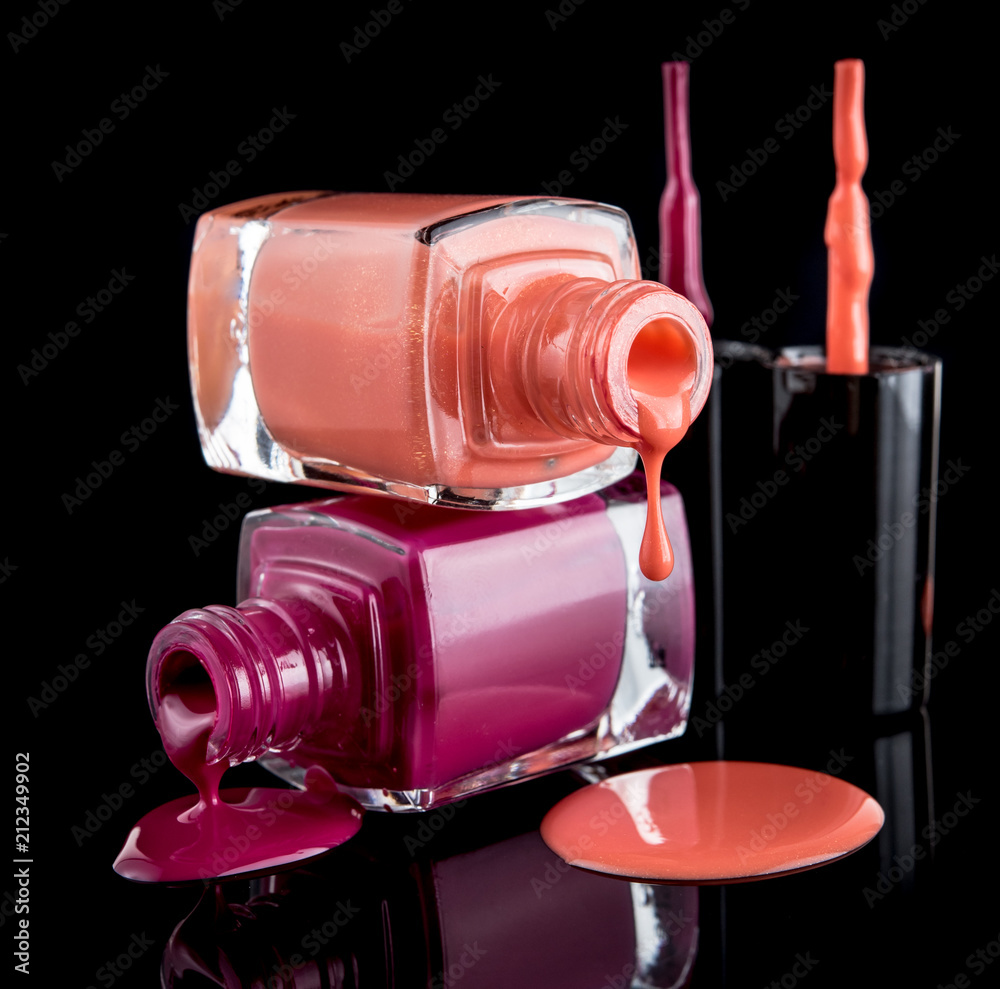 Nail polish colors spilling out of bottle on black background Nail polish colors spilling out of bottle on black background