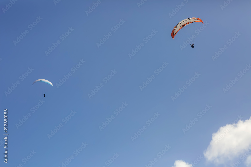 Paragliding on the blue sky and sea background, group of paragliders flying Paragliding on the blue sky and sea background, group of paragliders flying