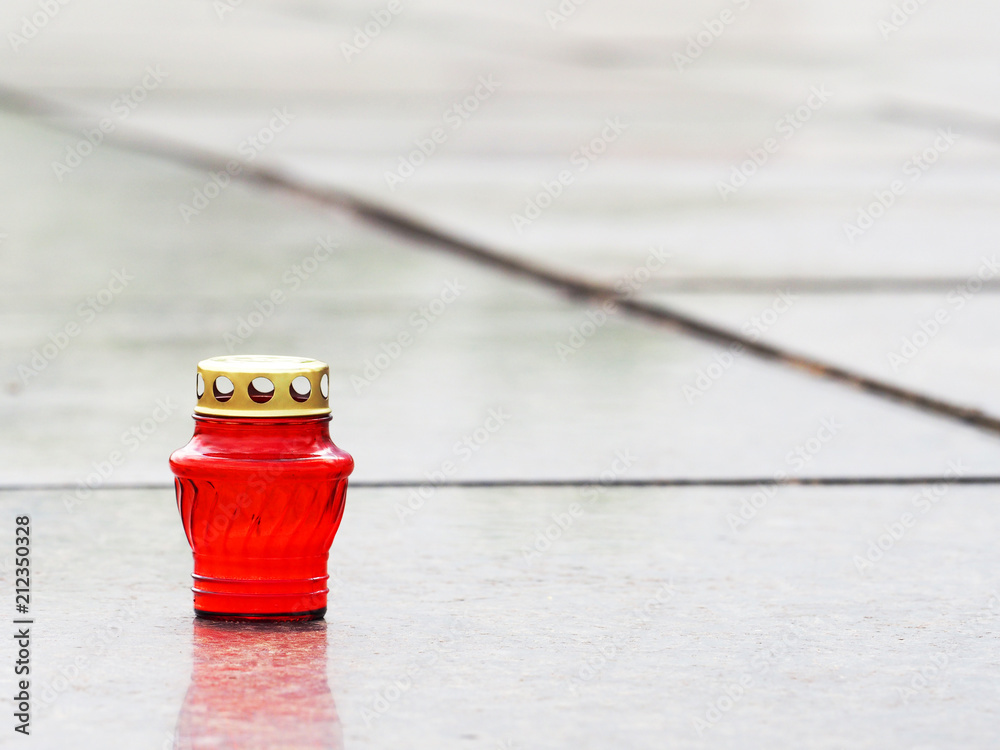 Church lantern and candle in memory of the dead. Candle in red glass on