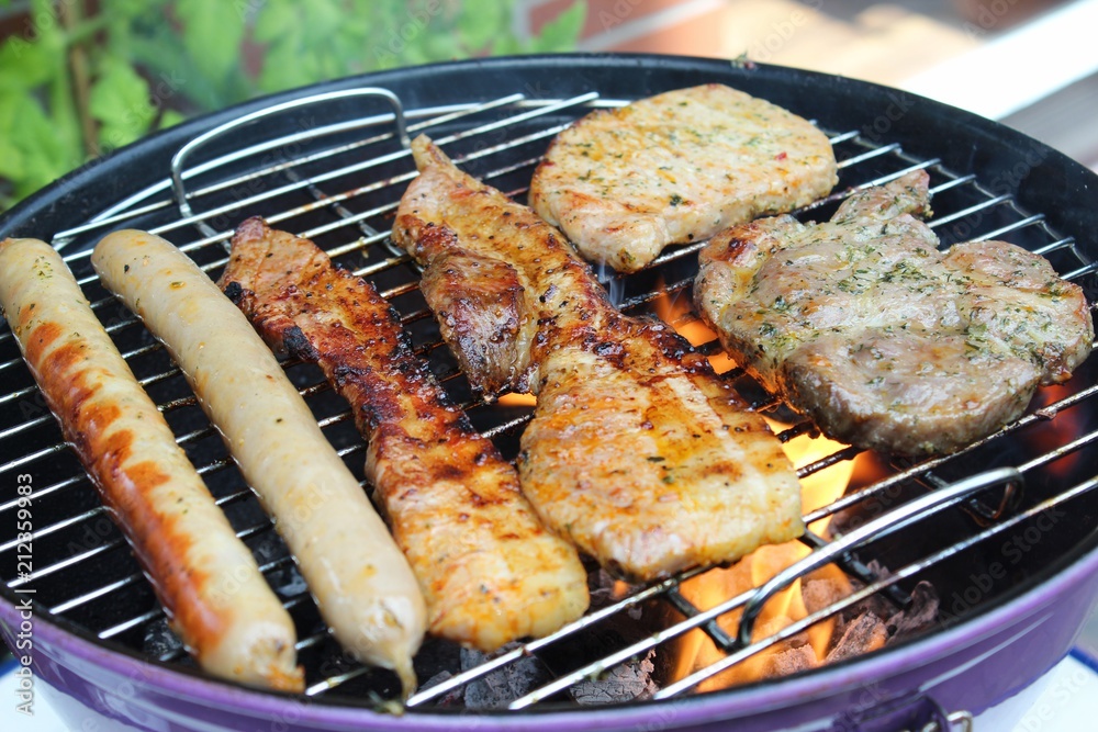 Bratwurst und mariniertes Fleisch (Nackensteak, Bauchfleisch) auf einem  Holzkohle-Grill Stock Photo | Adobe Stock