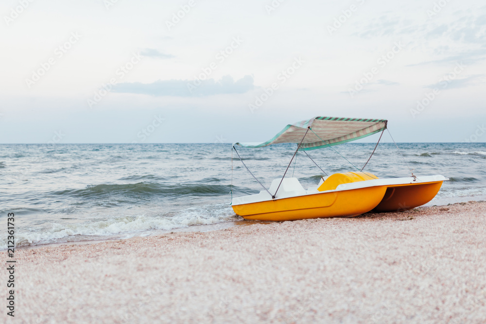 Fototapeta premium A catamaran standing on a beach with roof Evening time No people