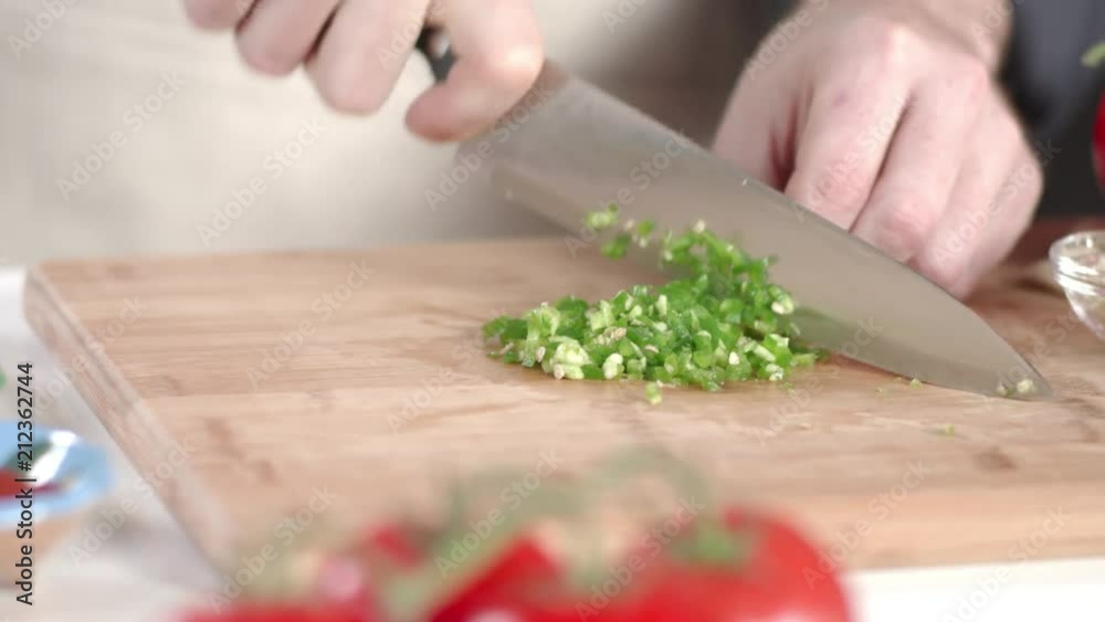 Slow-mo tracking shot of chef dicing jalapeno pepper with large kitchen knife Slow-mo tracking shot of chef dicing jalapeno pepper with large kitchen knife