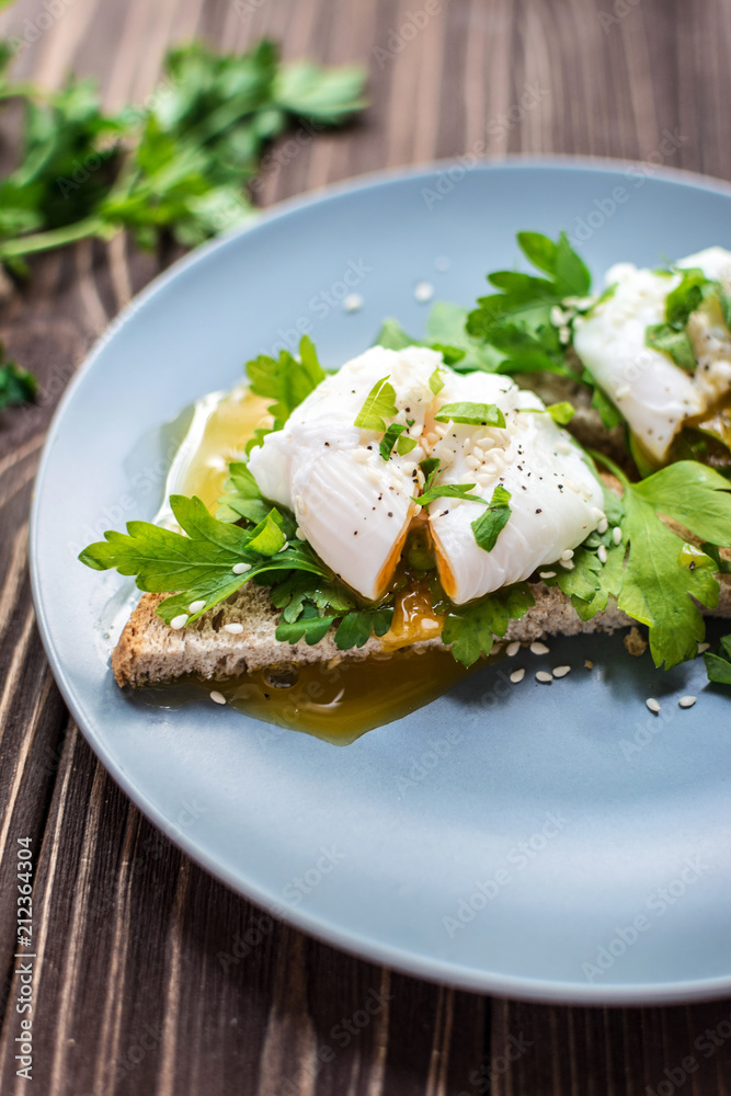 Homemade poached eggs on toast with fresh herbs and pepper Homemade poached eggs on toast with fresh herbs and pepper