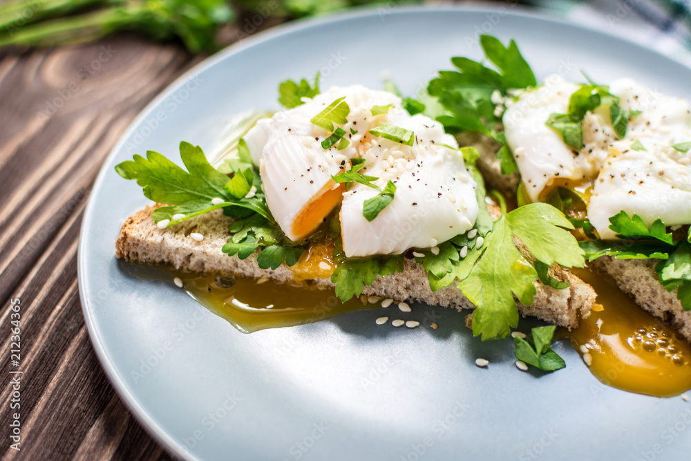 Homemade poached eggs on toast with fresh herbs and pepper Homemade poached eggs on toast with fresh herbs and pepper
