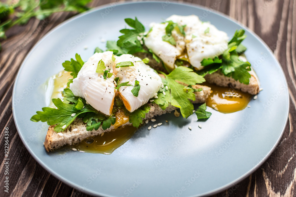 Homemade poached eggs on toast with fresh herbs and pepper Homemade poached eggs on toast with fresh herbs and pepper