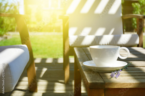 Foto Cup of tea served on natural wood table in the provence style backyard garden te