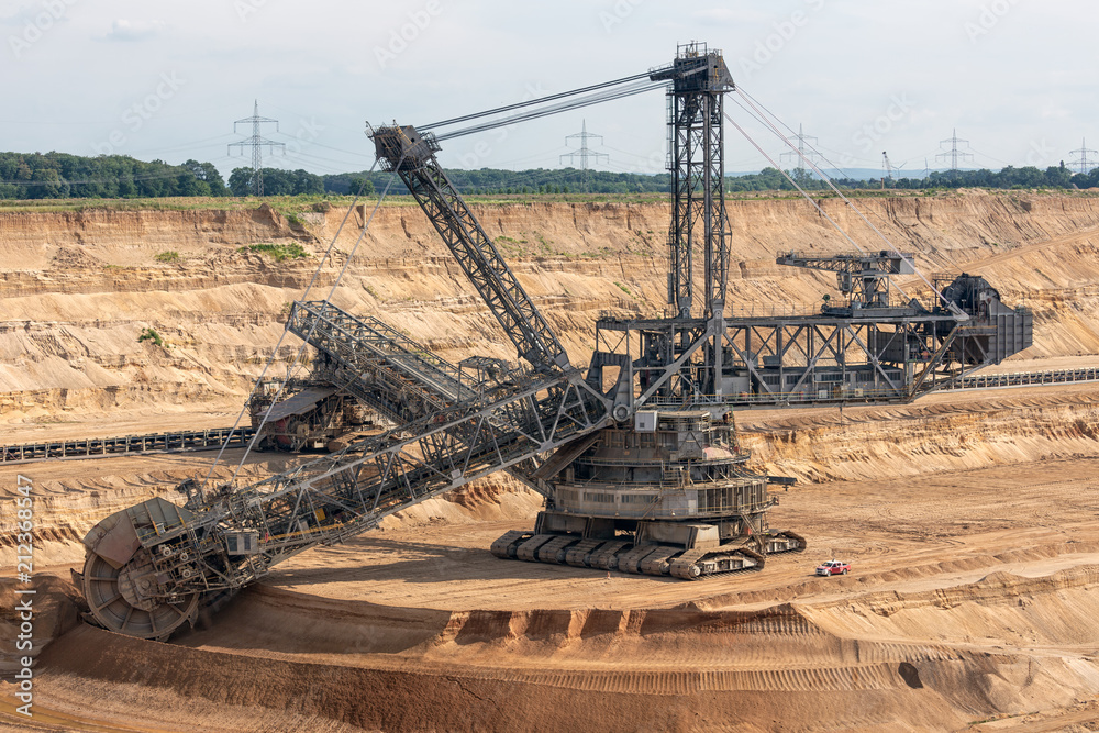 Brown coal open pit landscape with enormous digging excavator in Hambach mine Germany, This machine is the biggest vehicle in the world Brown coal open pit landscape with enormous digging excavator in Hambach mine Germany, This machine is the biggest vehicle in the world