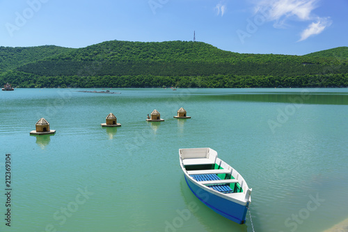Bright blue rowing boat on the emerald water of the mountain lake Abrau-Durso
