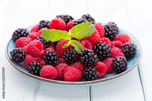 Fresh raspberries in a plate on a  vintage background.