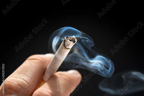 Qualmende Zigarette in Männerhand photo