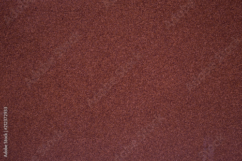 A wall covered with a stone crumb of the trendy color of a red pear
