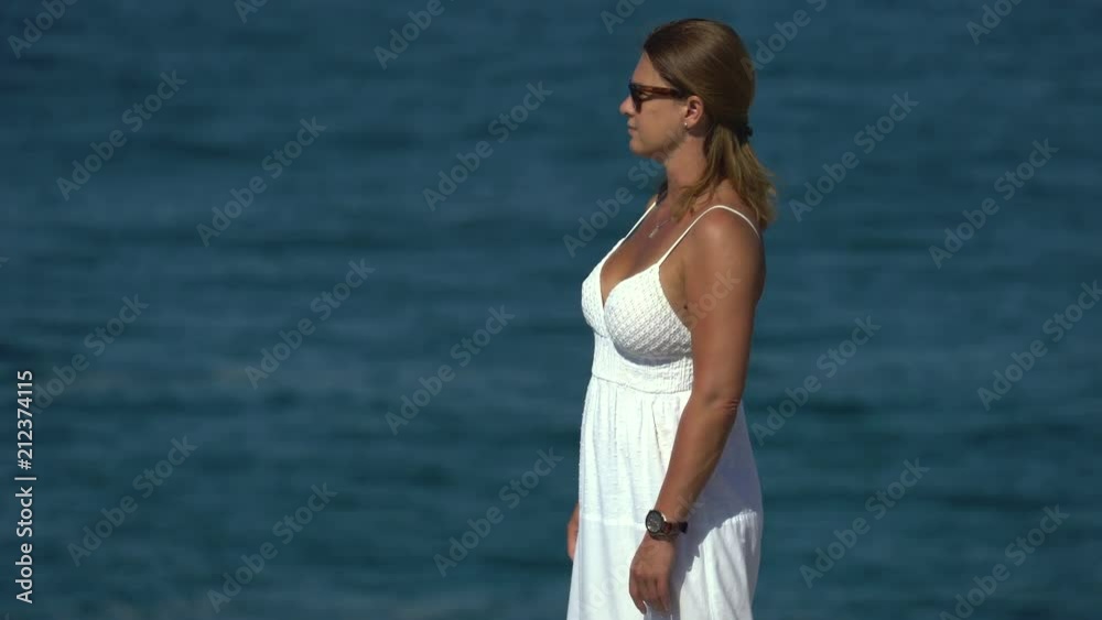 Woman look around on a cliff over ocean Woman look around on a cliff over ocean
