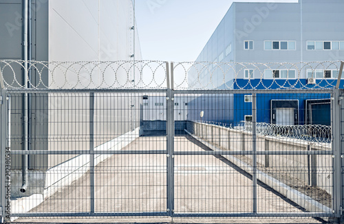 Photo Metal gates in an industrial area with barbed wire protection