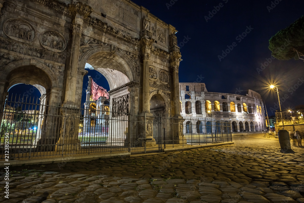 Antique arch of Constantine and colosseum in Rome at night, Italy