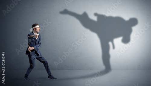 Young karate man confronting with his own shadow  © ra2 studio