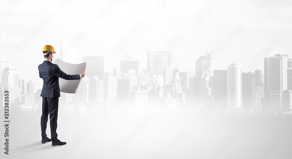 Young supervisor architect standing and looking at a big city panorama
Young supervisor architect standing and looking at a big city panorama