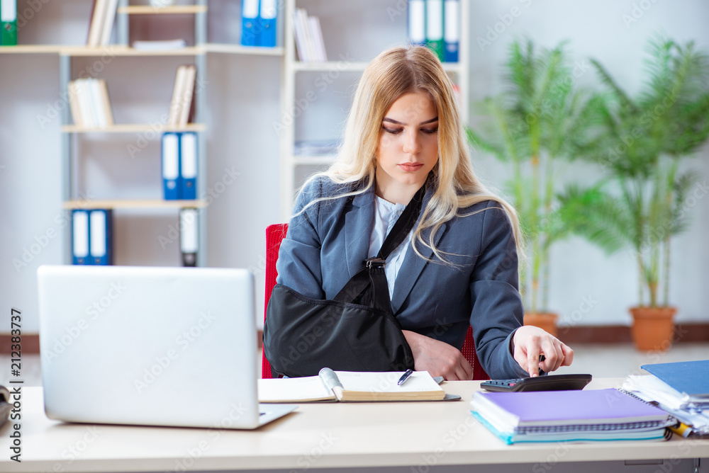 Injured female employee working in the office Injured female employee working in the office