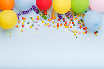 Birthday party background border with baloons and confetti, on blue surface with copy space
