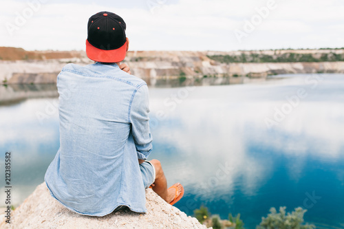 Portrait of a man sitting on a rock, travel around the island, a tourist on vacation