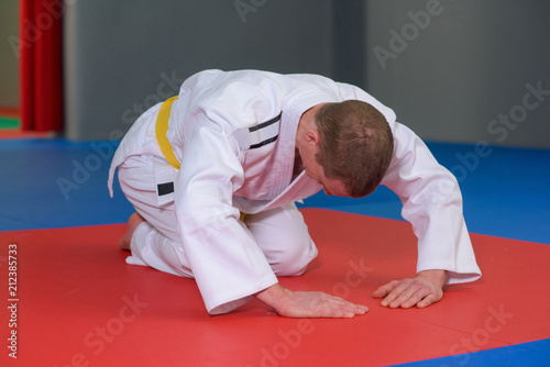 Man in kimono in bowed position on floor