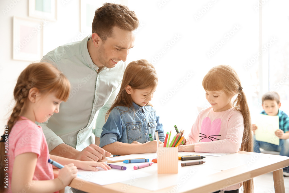 Cute little children with teacher in classroom at school Cute little children with teacher in classroom at school