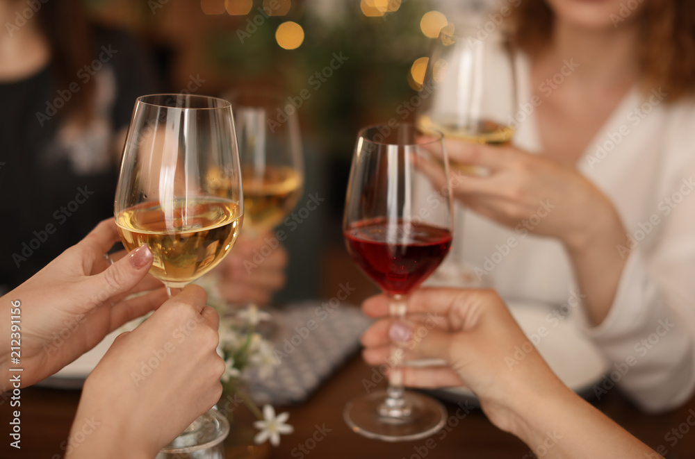 Young people with glasses of delicious wine at table