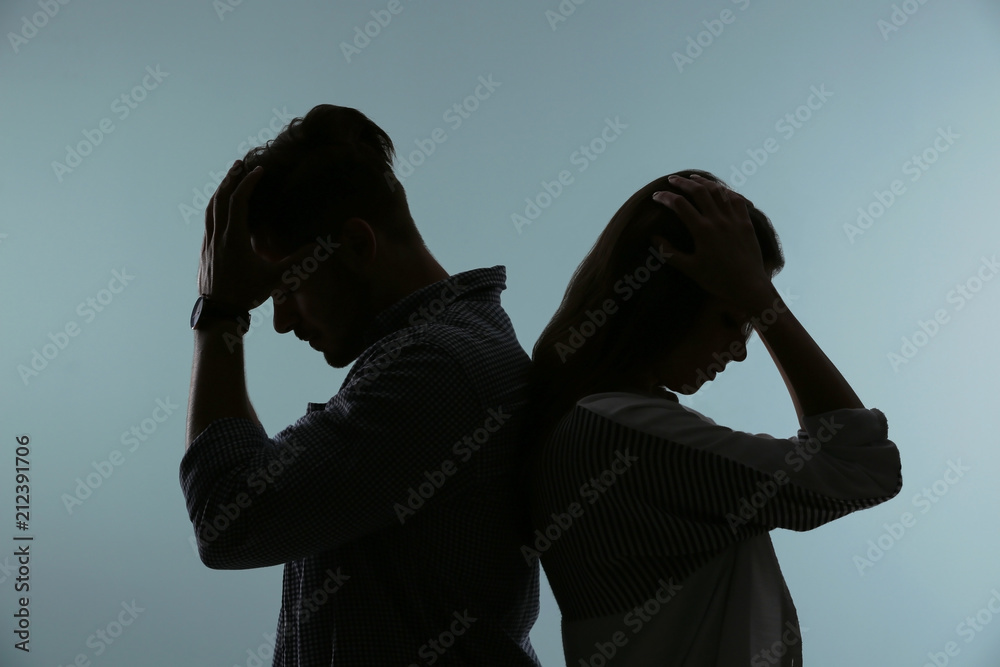 Silhouette of upset couple on color background. Relationship problems - obrazy, fototapety, plakaty 