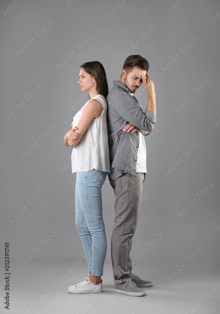 Upset young couple on grey background. Relationship problems Upset young couple on grey background. Relationship problems