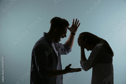 Silhouette of couple having argument on color background. Relationship problems photo