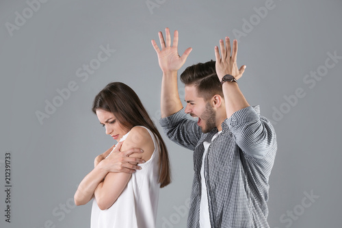 Fotografia Young couple having argument on grey background