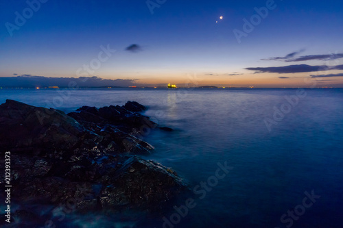 夜明けの三日月と金星が輝く磯で © Kouzi.Uozumi