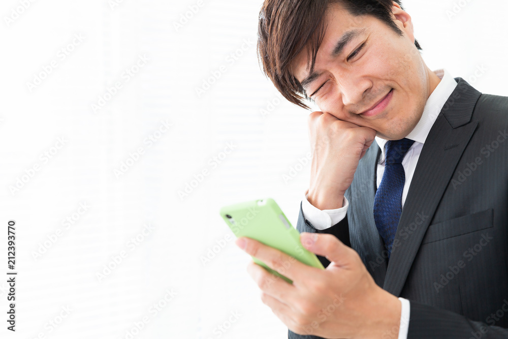 スマホを見るミドル男性　ビジネス　考える