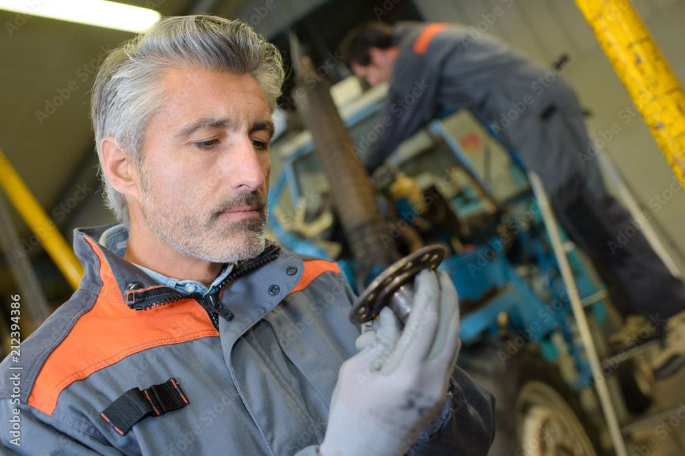 Mechanic looking at part Mechanic looking at part