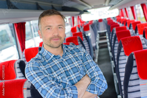 Portrait of man stood in aisle of empty bus