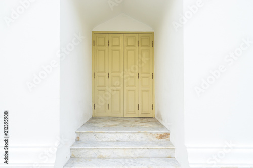 retro wood door on white cement wall and marble stair